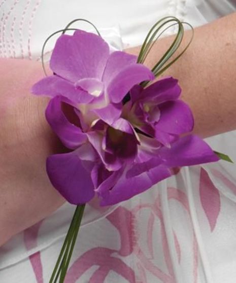 Purple dendrobium orchids accented with filler, greenery and ribbons.
