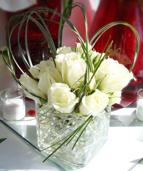 This year send luxury in a clear cube vase filled with winter white roses and artistic greenery.